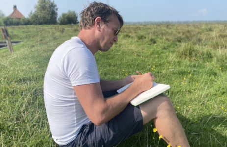 Niels schrijft in notitieboek in natuur canoe editie